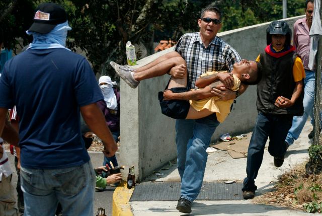 A man carries an injured anti-government protester in San Cristobal