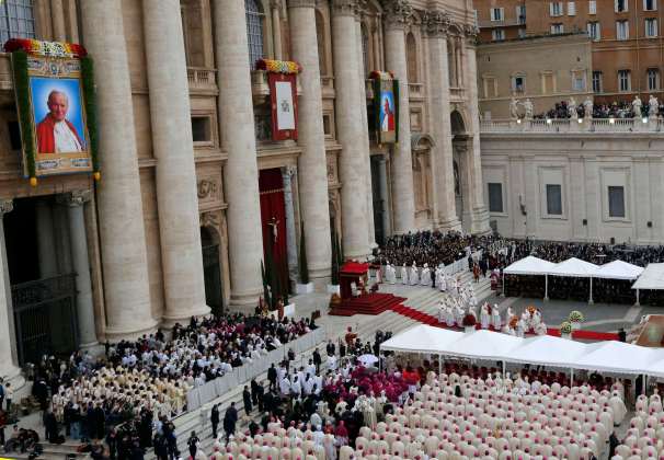 Tapestry portraits of Pope John Paul II and Pope John XXIII are seen in a general view of the mass before the canonisation ceremony in St Peter's Square at the Vatican