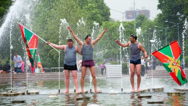 veteranos de servicios de guardia de fronteras rusas animan en una fuente, mientras que la celebración del Día de Frontera Guardias del Parque Gorki en Moscú / Dmitry Serebryakov / AFP