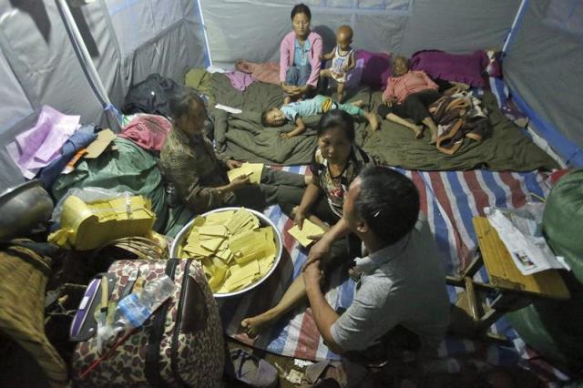 Supervivientes preparan un ritual funerario para sus familiares fallecidos en su tienda cerca de la ciudad de Longtoushan, en la provincia de Yunna (China). EFE