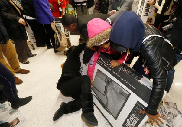 Shoppers wrestle over a television as they compete to purchase retail items on "Black Friday" at an Asda superstore in Wembley