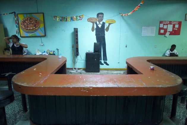 Waiters wait for clients in a pizzeria in Havana