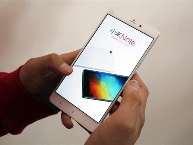 (CHINA) 12/02/2015.- Un usuario revisa un teléfono móvil Xiaomi en un centro de exposición de productos de Xiaomi en Pekín (China) hoy, jueves 12 de febrero de 2015. La compañía es el tercer productor de teléfonos más importante del mundo después de Apple y Samsung. El valor estimado de la compañía ronda los 50.000 millones de dólares. EFE/Wu Hong