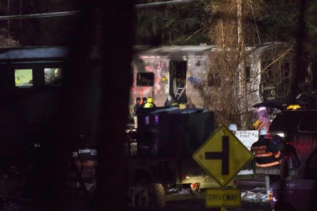 Bomberos y policía permanecen en el lugar donde se ha producido el choque entre un tren y un vehículo en Valhalla (Estados Unidos) ayer, martes 3 de febrero de 2015. Al menos siete personas murieron ayer en la localidad neoyorquina de Valhalla al arrollar un tren suburbano un vehículo que estaba detenido en las vías, informaron fuentes oficiales.  Fuentes de la Autoridad del Transporte Metropolitano (MTA, en inglés) y del condado donde se produjo el accidente dijeron que, además de las siete víctimas mortales, hay entre diez y doce heridos, algunos de ellos graves. EFE/John Taggart