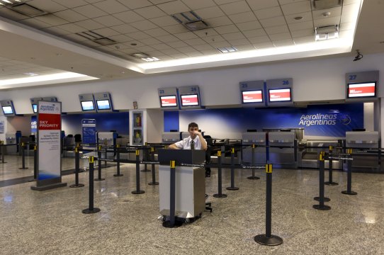 A private security man sits near the check-in desks of Aerolineas Argentinas at the Jorge Newbery domestic airport during a one-day nationwide strike in Buenos Aires