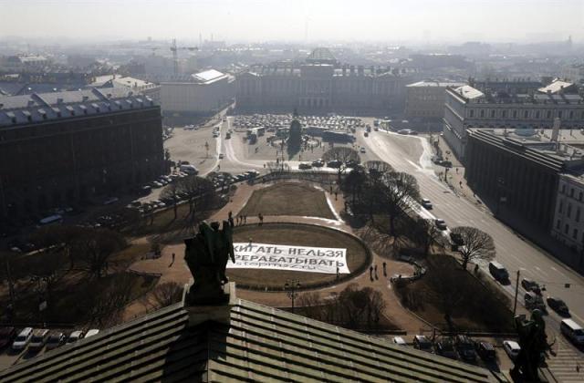 Activistas de Greenpeace muestran una pancarta en la que se puede leer "Lo quemado no puede ser reciclado" frente a la Catedral de Isaac durante una protesta contra las plantas icineradoras de basura en San Petersburgo (Rusia) hoy, martes 17 de marzo de 2015. EFE/Anatoly Maltsev