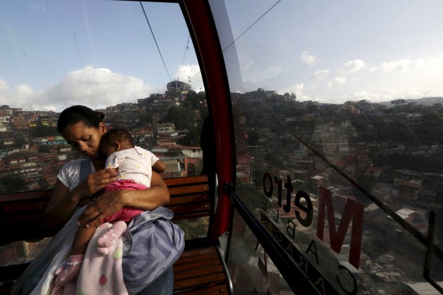 A woman hugs a baby in a cableway in Caracas