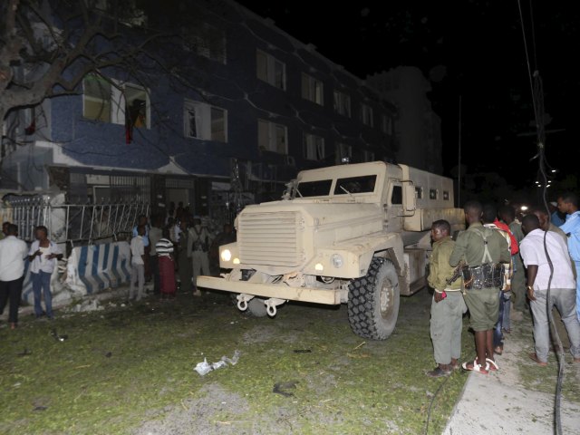 An APC drives past the scene of an explosion at the gate of Wehliya hotel in Somalia's capital Mogadishu