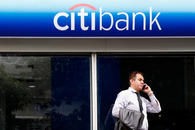 A man speaks on the phone outside a Citibank branch in Caracas