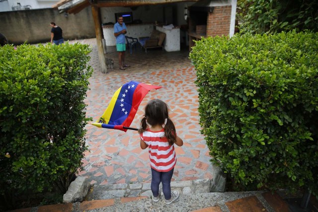 Matilda Medina waves the Venezuelan flag during a visit to bid goodbye in her grandparents' house, before her move to the U.S., in Valencia