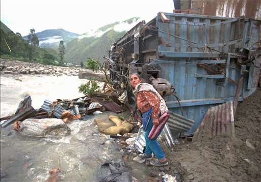 Una mujer busca pertenencias cerca de su casa destruida por un alud de lodo y piedras a causa de los aguaceros atribuidoas al fenómeno climático de El Niño en la localidad de Santa Teresa, en Cusco, Perú, el 15 de enero de 1998. El Niño actual, que comenzó en marzo, causa perjuicios y beneficios en diversas regiones en el mundo. En California confían que ayude a poner fin a la sequía, pero en otras partes causará perjuicios a cosechas y acarreará alzas de productos como café, chocolate y azúcar.  (AP Foto/Oscar Paredes)