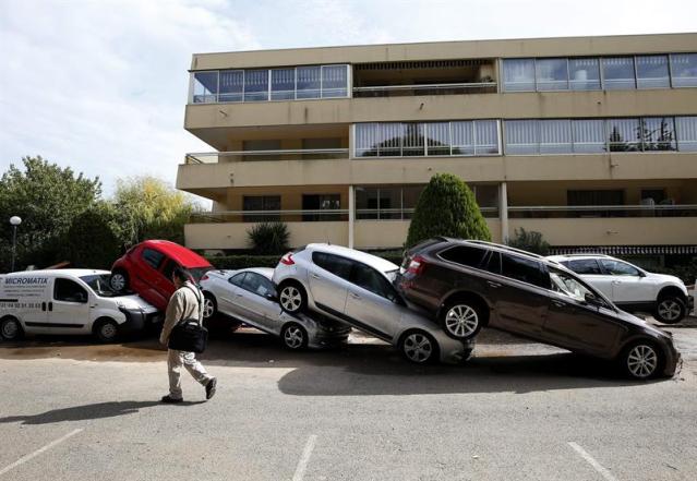 Un hombre pasa junto a varios coches amontonados tras ser arrastrados por la corriente durante las inundaciones en Boit, al sur de Francia, hoy, 5 de octubre de 2015. Cuatro personas permanecen desaparecidas hoy en la Costa Azul francesa tras las inundaciones que en la madrugada de ayer provocaron 17 muertos e importantes daños materiales en media docena de localidades. Los servicios de socorro albergan pocas esperanzas de encontrar con vida a los desaparecidos. EFE