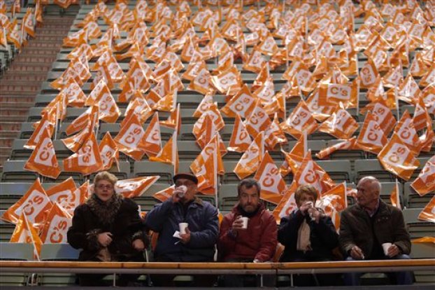 En esta imagen, tomada el 13 de diciembre de 2015, un grupo de personas bebe un chocolate caliente mientras espera el inicio de un acto electoral de Ciudadanos en Madrid, España. Las encuestas muestran que el Partido Popular del presidente Mariano Rajoy será el más votado, aunque no obtendría los apoyos necesarios para conservar la abrumadora mayoría que tiene en el Parlamento _ lo que supondría que tendría que asociarse con otra formación, probablemente Ciudadanos. Otra posibilidad podría ser una coalición entre los socialistas y Podemos. (Foto AP/Francisco Seco)