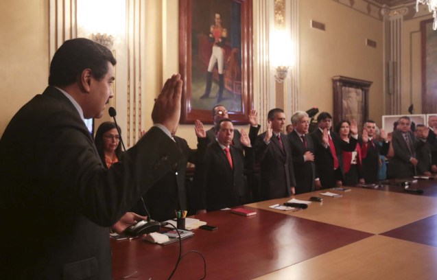 Venezuela's President Nicolas Maduro (L) takes an oath with ministers during a meeting at Miraflores Palace in Caracas, in this handout picture provided by Miraflores Palace on January 6, 2016. Venezuelan President Maduro named two university academics to major economic posts in a Cabinet reshuffle on Wednesday that came as a showdown intensified between his government and a new opposition-led legislature. REUTERS/Miraflores Palace/Handout via Reuters ATTENTION EDITORS - THIS IMAGE HAS BEEN SUPPLIED BY A THIRD PARTY. IT IS DISTRIBUTED, EXACTLY AS RECEIVED BY REUTERS, AS A SERVICE TO CLIENTS. FOR EDITORIAL USE ONLY. NOT FOR SALE FOR MARKETING OR ADVERTISING CAMPAIGNS.