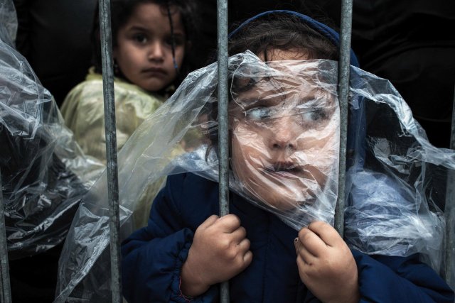 Primer premio de la gategoría "Gente", Matic Zorman. El niño se cubre con un impermeable mientras espera para registrarse en un campo de refugiados en Presevo, Serbia