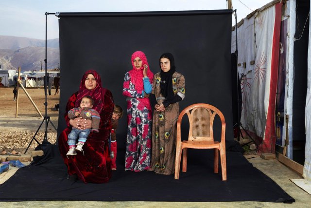Tercer premio de la categoría "Gente", Dario Mitidieri. Retrato de una familia de refugiados sirios en un campamento en el valle de la Bekaa, Líbano. La silla vacía en la fotografía representa un miembro de la familia que ha ya sea muerto en la guerra o c