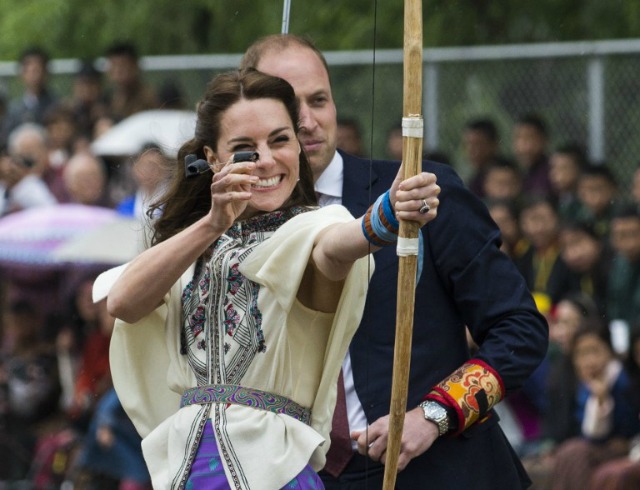 británica Catherine (L), la duquesa de Cambridge, dispara una flecha como Guillermo de Cambridge, mira al suelo Changlimithang Nacional de Tiro con Arco en Thimphu durante su visita a Bhután el 14 de abril de 2016. ROBERTO SCHMIDT / AFP
