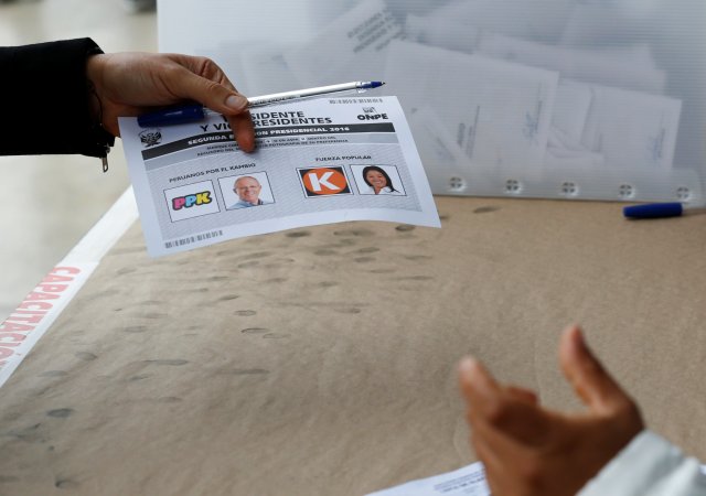 A woman recieves a ballot with the photographs of Peruvian presidential candidates Pedro Pablo Kuczynski (L) and Keiko Fujimori at a polling station in Lima, Peru, June 5, 2016.   REUTERS/Mariana Bazo