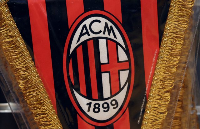 El logo de AC Milan es fotografiado en un banderín a la venta en una tienda en Milán, Italia. 29 de abril de 2015. Fininvest, el conglomerado de la familia del ex primer ministro italiano Silvio Berlusconi, confirmó el viernes que firmó un acuerdo preliminar para vender el 99,93 por ciento del club de fútbol AC Milan a un grupo de inversores chinos. REUTERS/Stefano Rellandini/File Photo