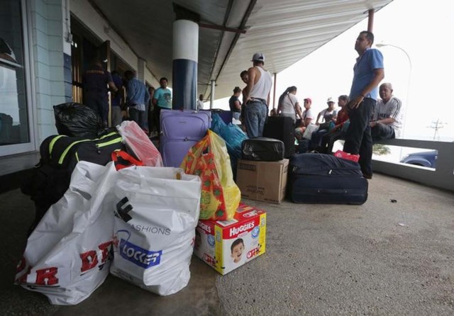 Venezolanos esperan con sus compras a un ferri privado en Trinidad para volver a casa. Foto tomada el 1 de junio del 2016. REUTERS/Andrea De Silva
