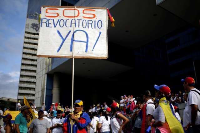 Un opositor sostiene un cartel durante una marcha en demanda de un referendo contra el presidente Nicolás Maduro, en Caracas, Venezuela. 1 de septiembre de 2016. Decenas de miles de venezolanos se congregaban el jueves para la "toma de Caracas", una marcha que la oposición prevé masiva y que busca presionar por una fecha para celebrar un referéndum revocatorio contra el presidente Nicolás Maduro. REUTERS/Marco Bello