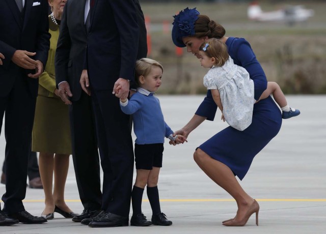 Britain's Catherine, Duchess of Cambridge holds the hand of her son Prince George while carrying Princess Charlotte as Prince William (L) speaks with officials as they arrive at the Victoria International Airport for the start of their eight day royal tour to Canada in Victoria, British Columbia, Canada, September 24, 2016.  REUTERS/Chris Wattie  TPX IMAGES OF THE DAY
