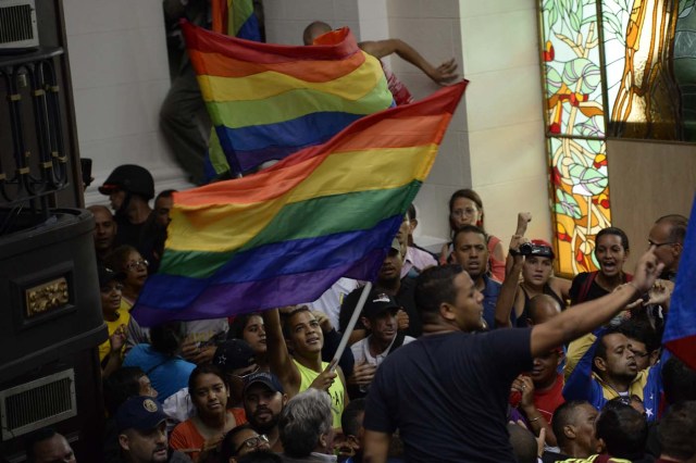 Supporters of Venezuelan President Nicolas Maduro force their way to the National Assembly during an extraoridinary session called by opposition leaders, in Caracas on October 23, 2016. The opposition Democratic Unity Movement (MUD) called a Parliamentary session to debate putting President Nicolas Maduro on trial to "restore democracy" in an emergency session that descended into chaos as supporters of the leftist leader briefly seized the chamber. / AFP PHOTO / FEDERICO PARRA