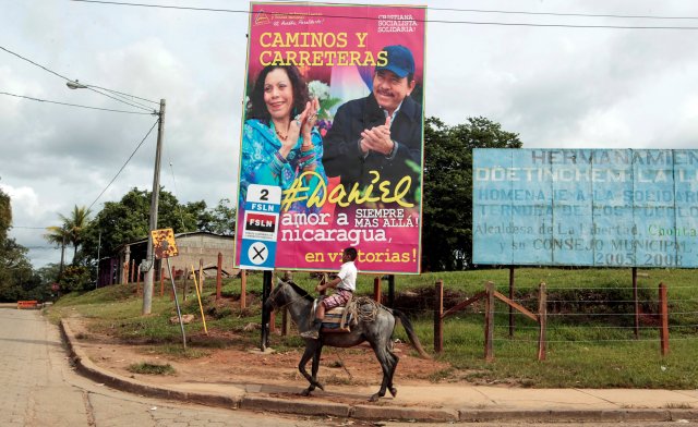 A boy rides his horse in front of a billboard for Nicaragua's President Daniel Ortega and his vice presidential candidate, first lady Rosario Murrillo in Ortega's childhood town of La Libertad, Nicaragua October 22, 2016. Picture taken October 22, 2016. REUTERS/Oswaldo Rivas
