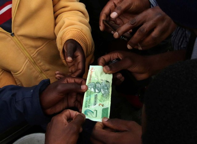 Illegal money changers having a feel of the new bond note in the capital Harare, Zimbabwe, November 28,2016.REUTERS/Philimon Bulawayo