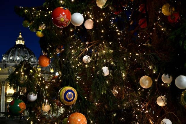 The Saint Peter dome is seen beside a Christmas tree displayed at the Saint Peter square on December 9, 2016. This year, the Christmas ornaments were made by children of the paediatric oncology departments of Italian hospitals. / AFP PHOTO / VINCENZO PINTO