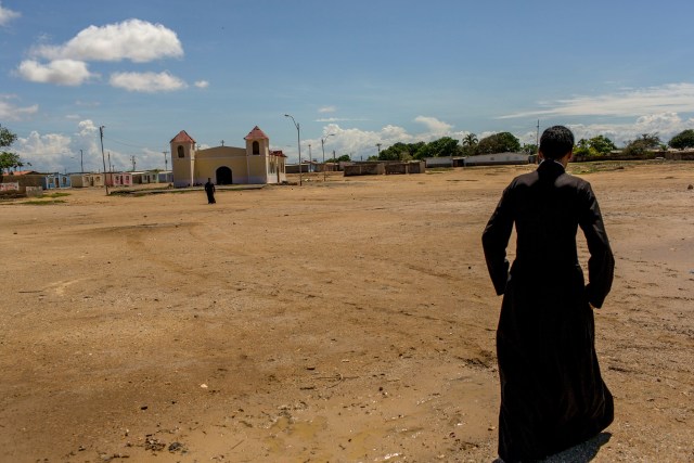 En esta foto del 6 de noviembre de 2016 un sacerdote camina hacia la capilla de Punta de Araya, estado de Sucre, Venezuela. La iglesia local trata de mediar entre las bandas rivales en la zona. (AP Foto/Rodrigo Abd)