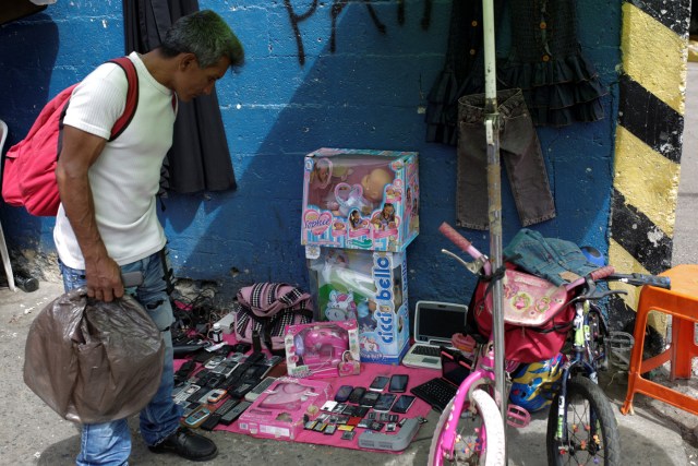 A man looks at second-hand toys at a street market in the slum of Catia in Caracas, Venezuela December 21, 2016. Picture taken December 21, 2016. REUTERS/Marco Bello