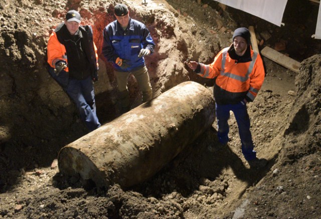 The bomb disposal team stand next to the World War II bomb they made safe in Augsburg, southern Germany, during a mass evacuation on December 25, 2016. Around 54,000 residents are being evacuated from their homes after the discovery of a bomb dating from World War II, local authorities said. / AFP PHOTO / dpa / Stefan Puchner / Germany OUT