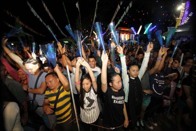 Revelers raise their plastic horns to welcome the new year at the Rizal Park in Davao City, Philippines December 31, 2016. REUTERS/Lean Daval Jr