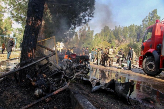 Afghan National Army (ANA) soldiers and firefighters extinguishe fire at the site of a suicide car bomb attack in Lashkar Gah in Helmand Province on February 11, 2017. At least six people were killed on February 11 when an explosives-laden car rammed into Afghan soldiers who had queued outside a bank in southern Helmand province to collect their salaries, officials said. / AFP PHOTO / NOOR MOHAMMAD