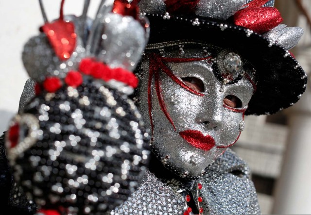 A masked reveller poses during the Venice Carnival in Venice, Italy February 12, 2017. REUTERS/Tony Gentile