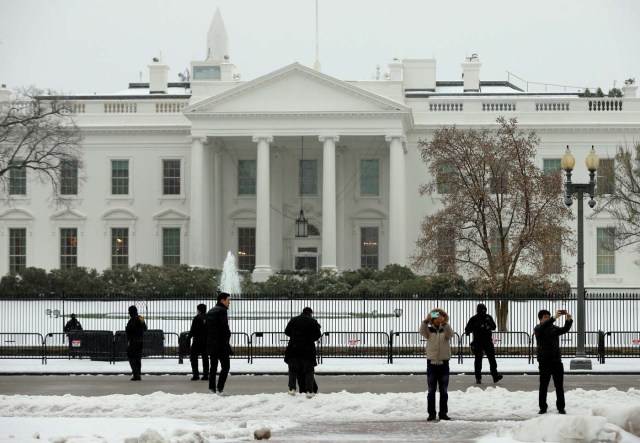 Tourists take photos in front of the White House on a snowy morning, in Washington, U.S., March 14, 2017. REUTERS/Kevin Lamarque