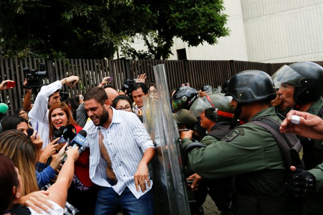 Juan Requesens, deputy of the Venezuelan coalition of opposition parties (MUD), talks to the media as he clashes with Venezuela's National Guards during a protest outside the Supreme Court of Justice (TSJ) in Caracas