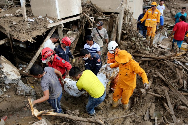 -FOTODELDIA- BOG201. MOCOA (COLOMBIA). 02/04/2017. Miembros de los equipos de emergencia rescatan el cuerpo de una mujer hoy, domingo 2 de abril de 2017, luego de una avalancha que afectó 17 barrios de la ciudad y que dejó más de 200 muertos en Mocoa, Putumayo (Colombia). El presidente de Colombia, Juan Manuel Santos, confirmó hoy que 210 personas fallecieron y 203 más resultaron heridas en la avalancha de tres ríos que arrasó parte de Mocoa, al tiempo que prometió la reconstrucción de esta ciudad ubicada en las selvas del sur del país. EFE/LEONARDO MUÑOZ