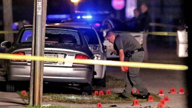 Un policía revisa el vehículo baleado en el que viajaban un hombre, una mujer y una niña de 9 años en West Park, Broward. Jim Donnelly Sun Sentinel 