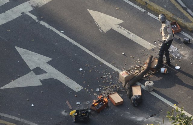 Queda un agente de las fuerzas de seguridad junto a los restos de la barricada levantada por la oposición. R. R. 