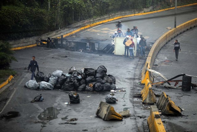 Un hombre camina al lado de la barricada luego de días de protestas contra el presidente venezolano Nicolás Maduro en la ciudad de Los Teques, cerca de Caracas, Venezuela, 19 de mayo de 2017. REUTERS/Carlos Barria