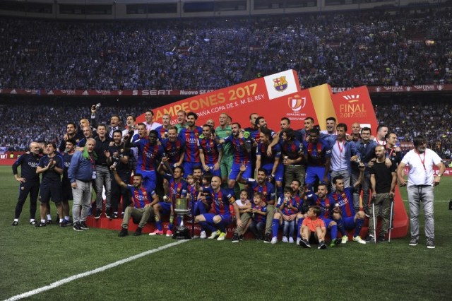 Barcelona players and staff pose with the trophy at the end of the Spanish Copa del Rey (King's Cup) final football match FC Barcelona vs Deportivo Alaves at the Vicente Calderon stadium in Madrid on May 27, 2017. Barcelona won 3-1. / AFP PHOTO / Josep LAGO