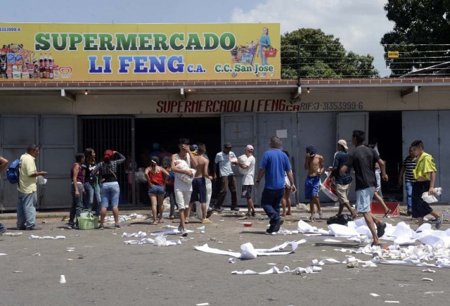 People loot a supermarket in Maracay, Aragua state, Venezuela on June 27, 2017. / AFP PHOTO / FEDERICO PARRA