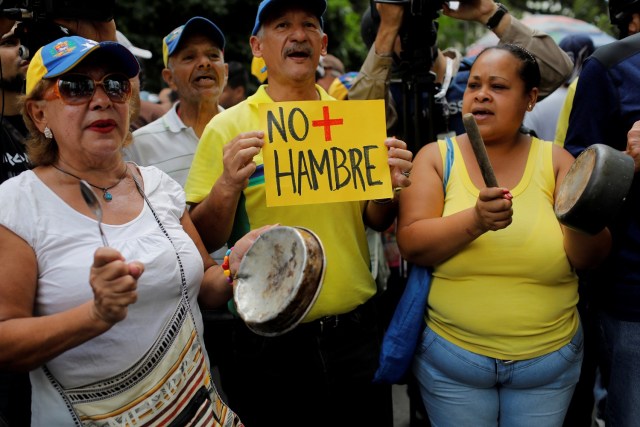 Los partidarios de la oposición que sostienen macetas y un cartel que dice: "no más hambrientos" asisten a la "marcha de las ollas vacías" contra el gobierno del presidente venezolano Nicolás Maduro en Caracas, Venezuela, June 3, 2017.  REUTERS/Marco Bello