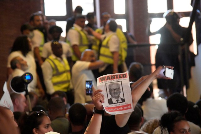 Los manifestantes son observados por el personal de seguridad en una escalera después de que entraron en el ayuntamiento de Kensington, durante una protesta después del incendio que destruyó el bloque de la torre Grenfell, en el norte de Kensington, Londres oeste, Reino Unido 16 de junio de 2017. REUTERS / Toby Melville