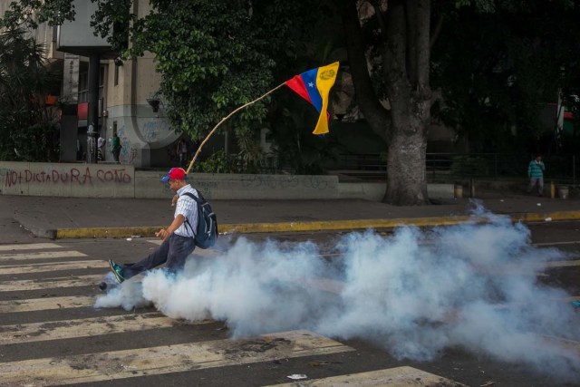 VEN06. CARACAS (VENEZUELA), 14/06/2017.- Un hombre patea una bomba de gas lacrimógeno durante una manifestación hoy, miércoles 14 de junio de 2017, en Caracas (Venezuela). Una concentración de venezolanos opositores al Gobierno de Nicolás Maduro se disolvió hoy en la localidad de Altamira, un bastión del antichavismo en el este de Caracas, luego de que se efectuaran varios disparos en el sitio, constató Efe. EFE/Miguel Gutiérrez