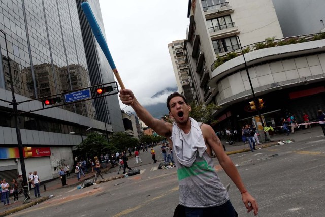 A demonstrator holding a bat shouts slogans while blocking a street during a protest against Venezuelan President Nicolas Maduro's government in Caracas, Venezuela July 19, 2017. REUTERS/Carlos Garcia Rawlins