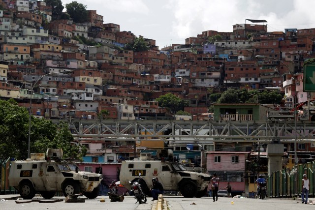 La gente pasa por una calle bloqueada por las fuerzas de seguridad durante una huelga convocada para protestar contra el gobierno del presidente venezolano Nicolás Maduro en Caracas, Venezuela, 20 de julio de 2017. REUTERS / Marco Bello