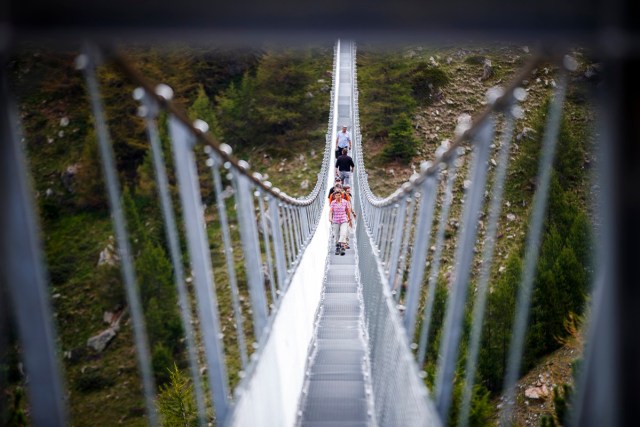 People walk on the "Europabruecke",  supposed to be the world's longest pedestrian suspension bridge with a length of 494m, after the official inauguration of the construction in Randa, Switzerland, on Saturday, July 29, 2017. The bridge is situated on the Europaweg that connects the villages of Zermatt and Graechen. (Valentin Flauraud/Keystone via AP)